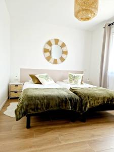 a bedroom with a bed and a mirror on the wall at Le Gîte "Aubrac" Haut de gamme, Jardin, Piscine in Gabriac
