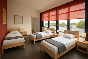 deux lits dans une chambre avec deux fenêtres dans l'établissement Monteur- und Ferienunterkunft Ludwigsfelde, à Ludwigsfelde