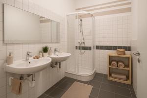 une salle de bain blanche avec deux lavabos et une douche dans l'établissement Monteur- und Ferienunterkunft Ludwigsfelde, à Ludwigsfelde
