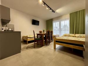 a living room with a kitchen and a dining room at Pokoje gościnne Denega in Jastarnia