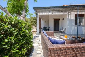 eine Außenterrasse mit Korbmöbeln und Pflanzen in der Unterkunft Claudia Bay Villa in Torre Lapillo + 19 Fotos