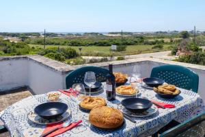 einen Tisch mit Speisen und Wein darauf in der Unterkunft Claudia Bay Villa in Torre Lapillo