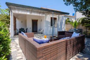 eine Terrasse mit Korbmöbeln vor einem Haus in der Unterkunft Claudia Bay Villa in Torre Lapillo
