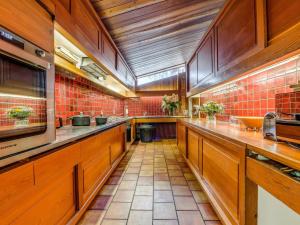 une grande cuisine avec des armoires en bois et du carrelage rouge dans l'établissement Magnifique Chalet au Calme près des Remontées Mécaniques à Val-d'Isère - FR-1-519-32, à Val dʼIsère 18 autres photos