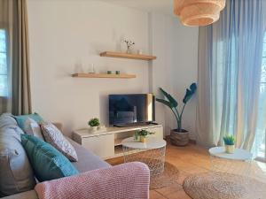 Casa Buena Vista - Rural Oasis في Alajeró: غرفة معيشة مع أريكة وتلفزيون