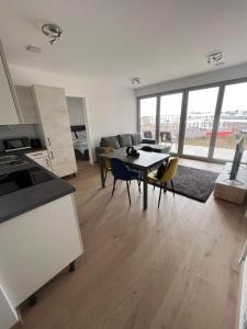 a kitchen and living room with a table and chairs at Cloche d Or modern 2 bed in Luxembourg