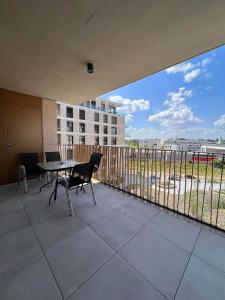a balcony with a table and chairs and a view of a building at Cloche d Or modern 2 bed in Luxembourg