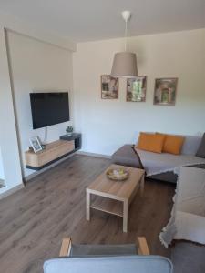 a living room with a couch and a tv at Studio4U in Néa Karváli +2 photos