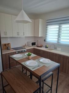 a kitchen with a wooden table with plates on it at Studio4U in Néa Karváli +3 photos