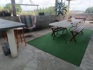 a table and chairs on a patio with a green rug at Mini apartamento 2 habitaciones in Ciudad Guayana