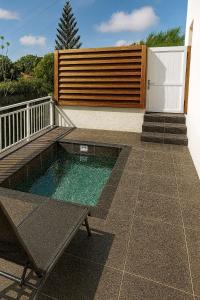 a small swimming pool on a patio next to a fence at Ti Zeinga la in Sainte-Anne