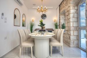 Un comedor con una mesa con sillas y una lámpara de araña. en Mountain Top Views -203- נופי פסגות, en Safed