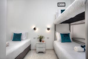 2 camas en una habitación con paredes blancas y almohadas azules en Mountain Top Views -203- נופי פסגות, en Safed 2 fotos más