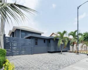 una casa con una valla azul y palmeras en The Urbanest, en Lagos