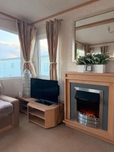 a living room with a fireplace and a tv at Caravan Wendy 2 Bed Adapted Caravan in Meliden