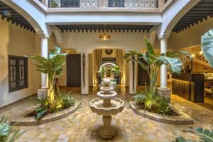 eine Lobby mit einem Brunnen in der Mitte eines Gebäudes in der Unterkunft Riad Bijoux Marrakech in Marrakesch