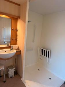 a small bathroom with a sink and a shower at Caravan Wendy 2 Bed Adapted Caravan in Meliden +11 photos