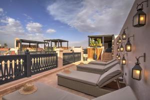 ein Balkon mit mehreren Stühlen und Tischen auf einer Terrasse in der Unterkunft Riad Bijoux Marrakech in Marrakesch + 85 Fotos