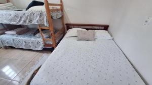 ein kleines Schlafzimmer mit zwei Etagenbetten darin in der Unterkunft KITNET S2 em TORRES-RS - Na mais bela praia Gaúcha - Cozinha - Banheiro - Ar condicionado - TV smart 32' - Wi-Fi - Estacionamento - Anfitriã Superhost no BnB in Torres + 26 Fotos
