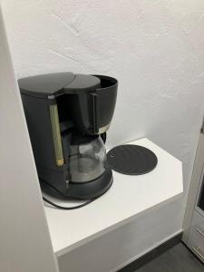 Eine schwarze Kaffeemaschine steht auf einem weißen Regal. in der Unterkunft Ferienwohnungen Albers in Winterberg