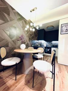 een eetkamer met een tafel en stoelen en een keuken bij PORT19 in Wrocław