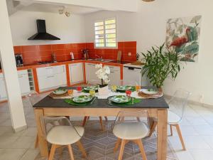 a kitchen with a wooden table and chairs at Villa Mahault in Petit-Bourg +7 photos