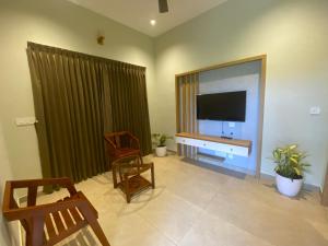a living room with a large flat screen television at Skyleaf Resort in Meenangadi