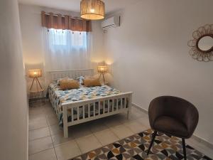 a bedroom with a bed and a chair in it at Villa Mahault in Petit-Bourg