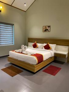 a bedroom with a large bed with a wooden headboard at Skyleaf Resort in Meenangadi