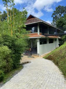 a house with a walkway in front of it at Skyleaf Resort in Meenangadi