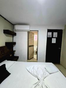 a bedroom with a white bed and a mirror at Casa ALCATRAZ in Cartagena de Indias