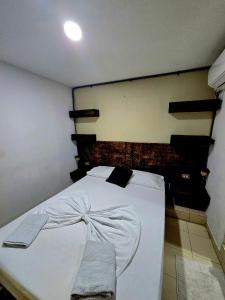 a bedroom with a white bed with a wooden headboard at Casa ALCATRAZ in Cartagena de Indias