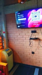 un mur avec une télévision sur un mur de briques dans l'établissement appart OUR HOME, à Palimé