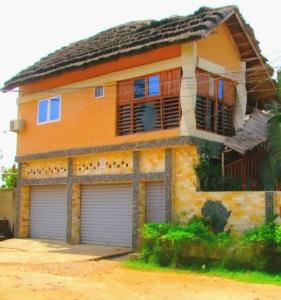 une maison avec deux portes de garage devant elle dans l'établissement appart OUR HOME, à Palimé