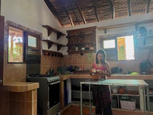 a woman standing in a kitchen with a bowl on a table at Marumar in Popoyo