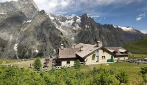 a house on a hill with mountains in the background at Mansarda in Morgex