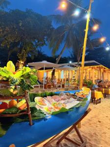 富国纳澜度假酒店的夜晚沙滩上的一张桌子，上面摆着食物。