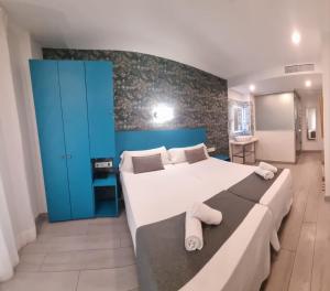 a bedroom with a large bed and a blue wall at Hotel Clopy Rocamar in Benidorm