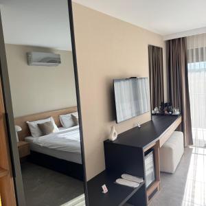 een hotelkamer met een bed en een spiegel bij Apartmani Tanasijević  +2 foto's