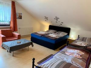 une chambre avec deux lits et une chaise dans l'établissement Ferienhaus Erika, à Zorge