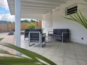 a patio with two chairs and a table at Villa Mahault in Petit-Bourg