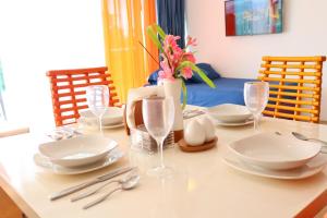 Una mesa de comedor con platos blancos y cubiertos sobre ella. en Oceanfront Studio Beach and Pool, en María Chiquita