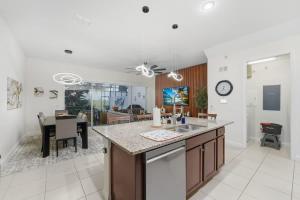 a kitchen and living room with a table and a counter at Tranquil Times Townhouse 4 bed Private Pool in Davenport +35 photos