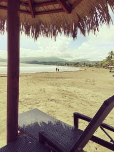una playa con sombrilla y silla en la playa en Oceanfront Studio Beach and Pool, en María Chiquita