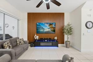 a living room with a couch and a tv on a wall at Tranquil Times Townhouse 4 bed Private Pool in Davenport