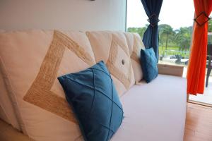 un sofá con almohadas azules en la sala de estar. en Oceanfront Studio Beach and Pool, en María Chiquita