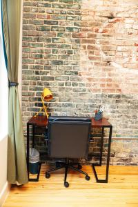 Un escritorio con un televisor frente a una pared de ladrillos. en Loft 308 - The William - Views over Carrigans, en Birmingham