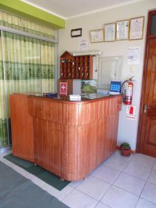 a wooden reception counter in a room with a window at Hostal Campestre Casa Blanca in Chucuito