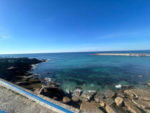 a view of the ocean with rocks and water at Summer Haze Ericeira in Ericeira