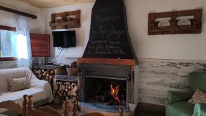 a living room with a fireplace with a chalkboard on the wall at La María de Tortas in Paterna del Madera